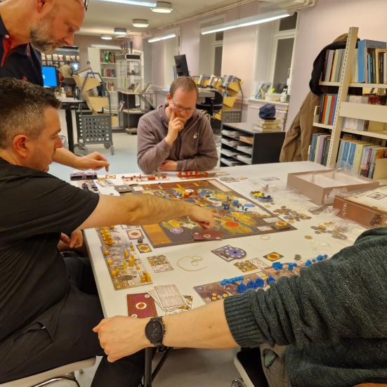 Folk der sidder ved et bord med brætspil