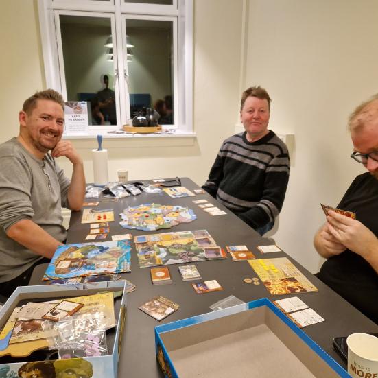 Folk der sidder ved et bord med brætspil