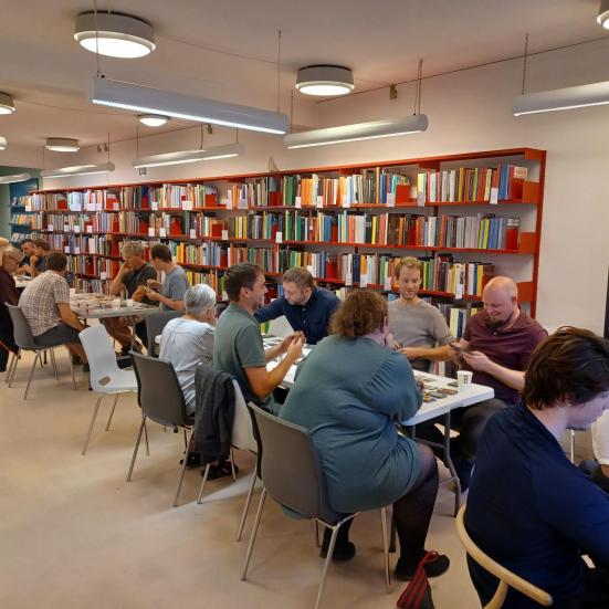 Personer som sidder og spiller brætspil