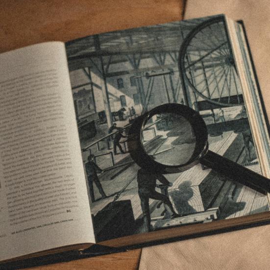 Åben bog med en lup liggende på den ene side