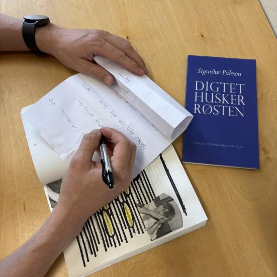 Hånd er i gang med at skrive et digt