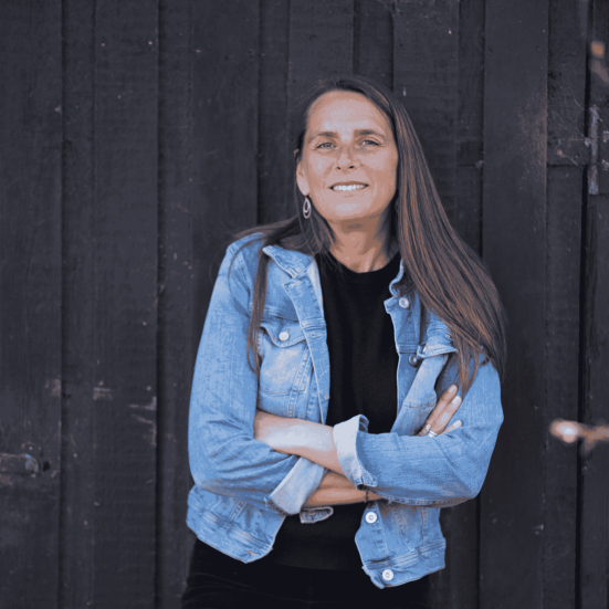 Anne Hjernøe står op ad sort væg