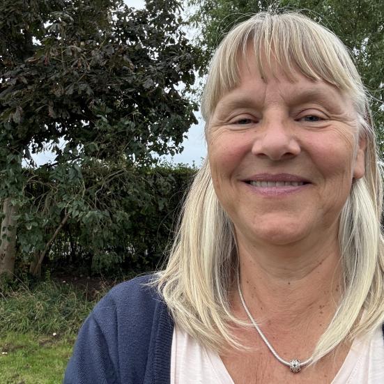 Billedet viser Malene Juel Jensen smilende i en have