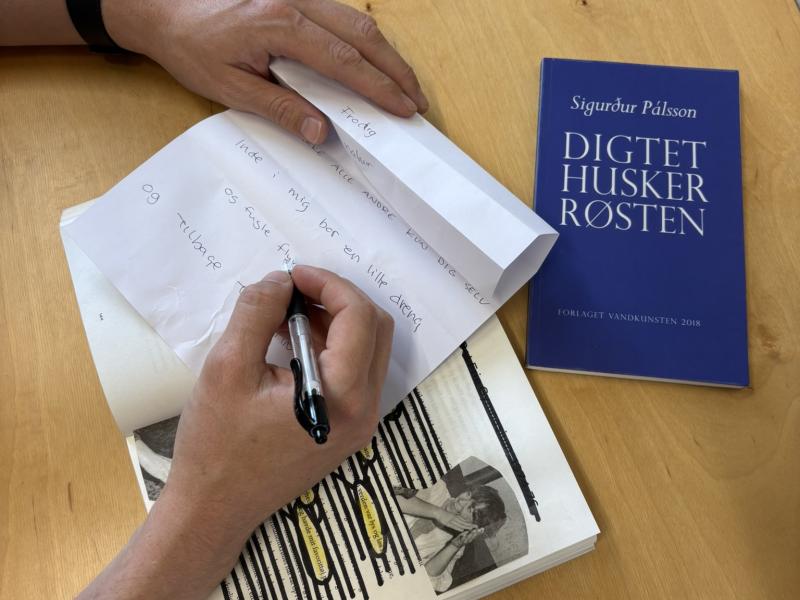 Hånd er i gang med at skrive et digt