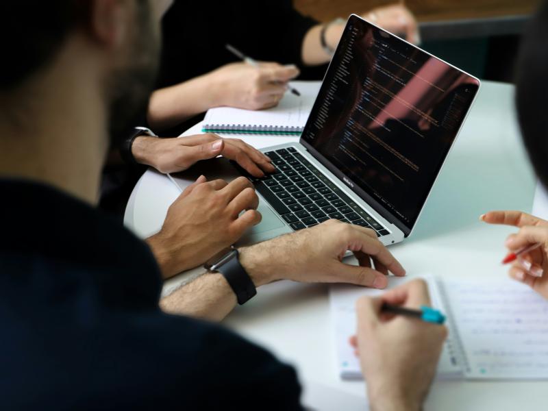 Mennesker mødes omkring en computer