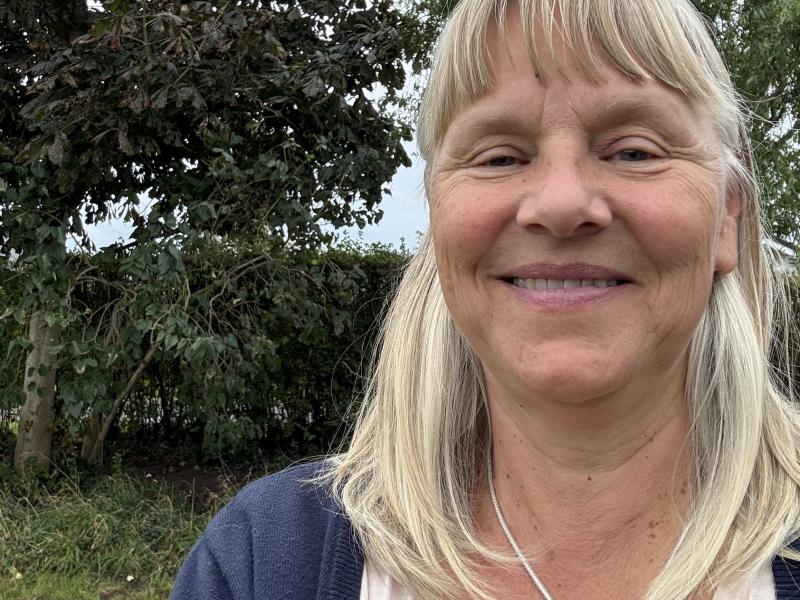 Billedet viser Malene Juel Jensen smilende i en have