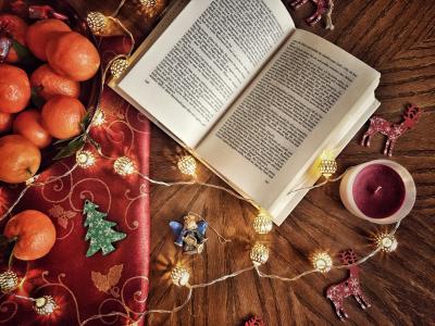 Åben bog på gulv omringet af julepynt