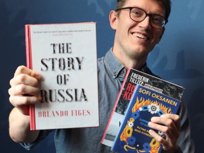 Kulturformidler Dennis Odgaard står og holder tre bøger om Rusland