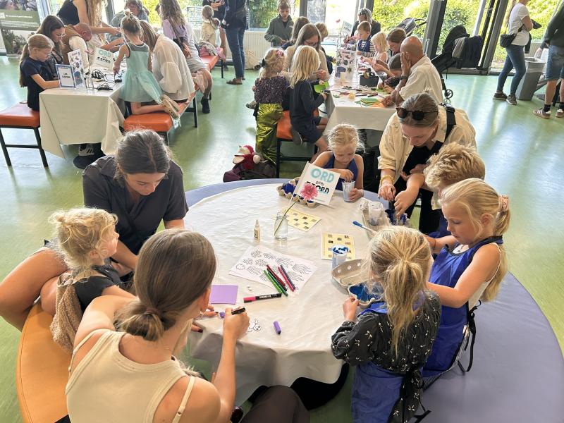 Børn der sidder omkring et bord og tegner og maler til ORD over FJORD 2025