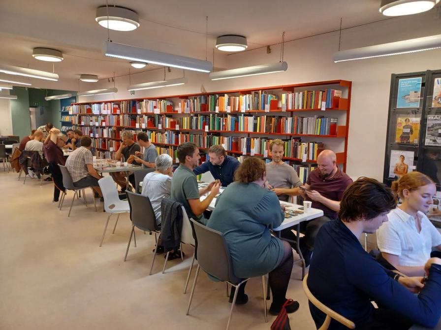 Personer som sidder og spiller brætspil