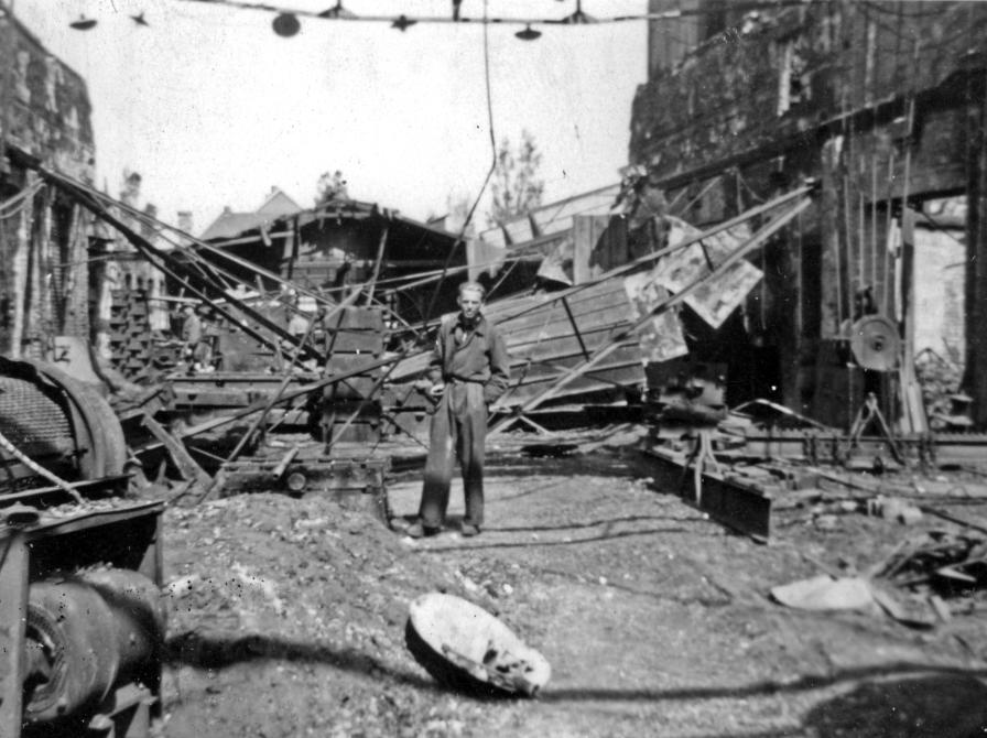 Sort-hvid foto af mand i en gade omringet af ødelæggelser efter sabotage