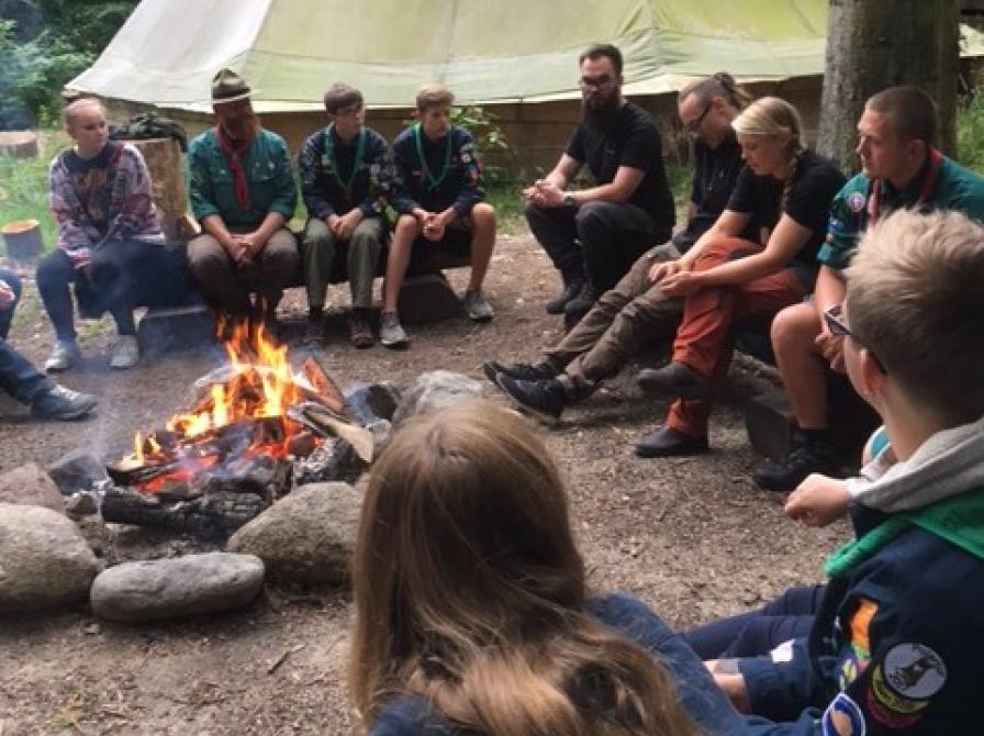 spejdere der sidder omkring et bål